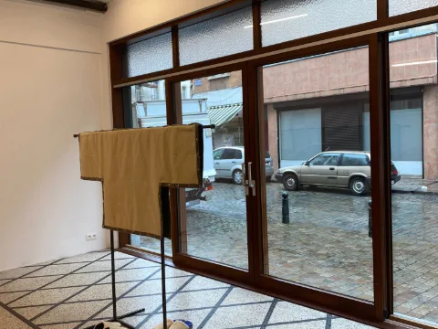 Sur une machine industrielle JUKI, des mains guident un tissu noir à franges assemblé à un jersey bordeaux.