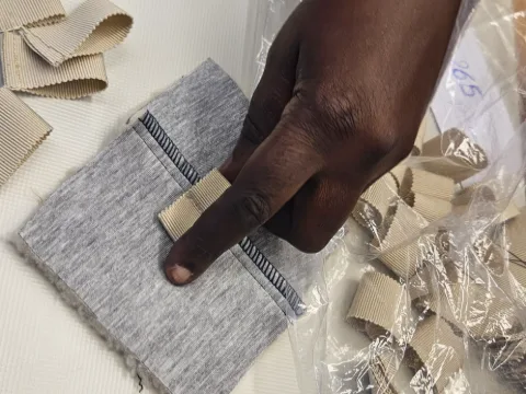 Détail d’une fausse fourrure rose vif ornée de cabochons irisés.