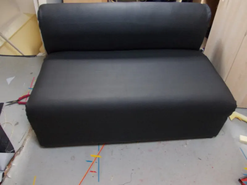 Zitbank, opgevuld en bekleed met zwarte stof, afgewerkt in het atelier.