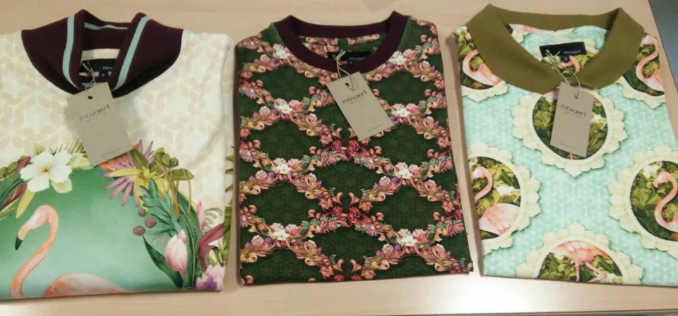 Trois hauts imprimés pliés avec leurs étiquettes de marque.